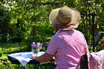 Frau am Gartentisch sitzend