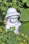 Mädchen-Skulptur im Blumenbeet